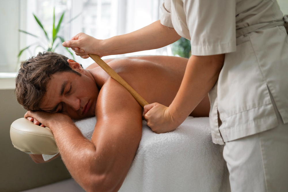 Mit wird am Rücken mit einer Massagerolle massiert