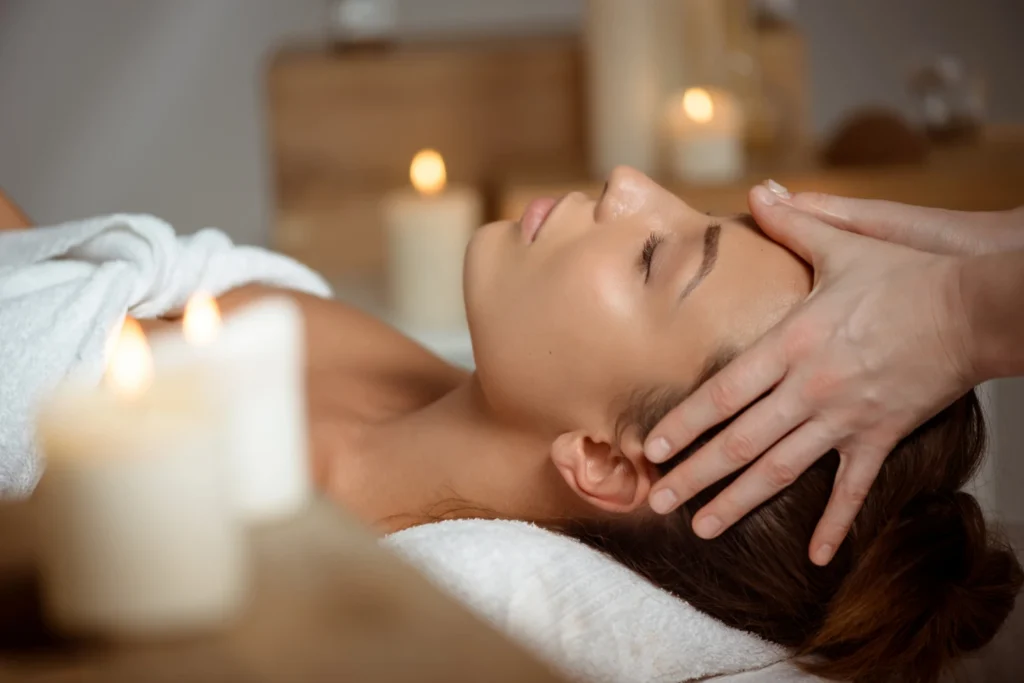Eine liegende Frau erhält eine Kopfmassage